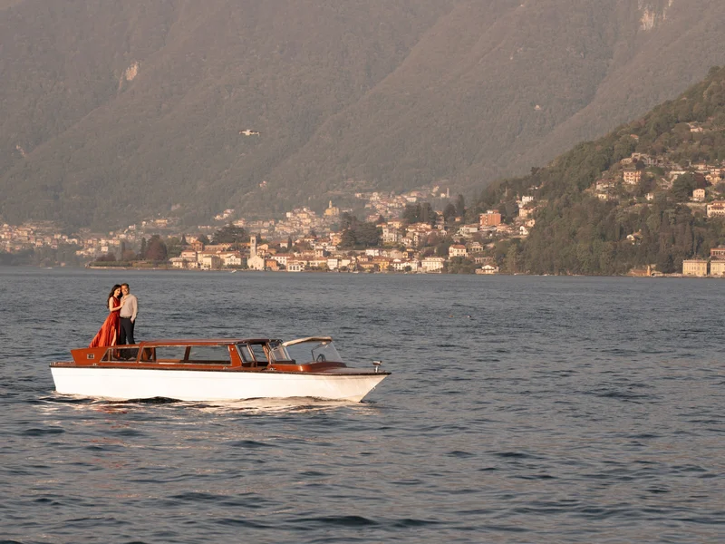 Classic wooden limo taxi cruising on Lake Como with mountain views